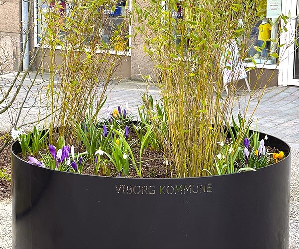 Planteringe malet i sort med et bed til blomster og planter