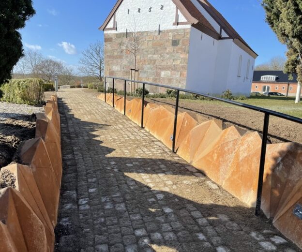 corten stensætning Stålkant i 5 mm cortenstål med 452 trekantede plader og integreret belysning – forener moderne design med historiske rammer.