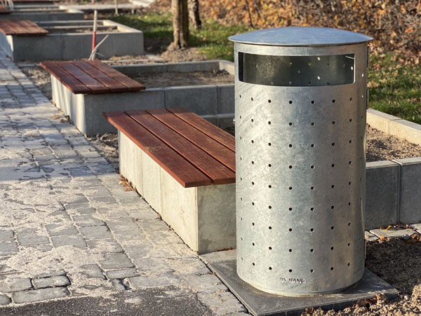 By Bang møbler, en stor udendørs skraldespand i galvaniseret stål og et originalt design med en betonplanterkasse med et træ sæde
