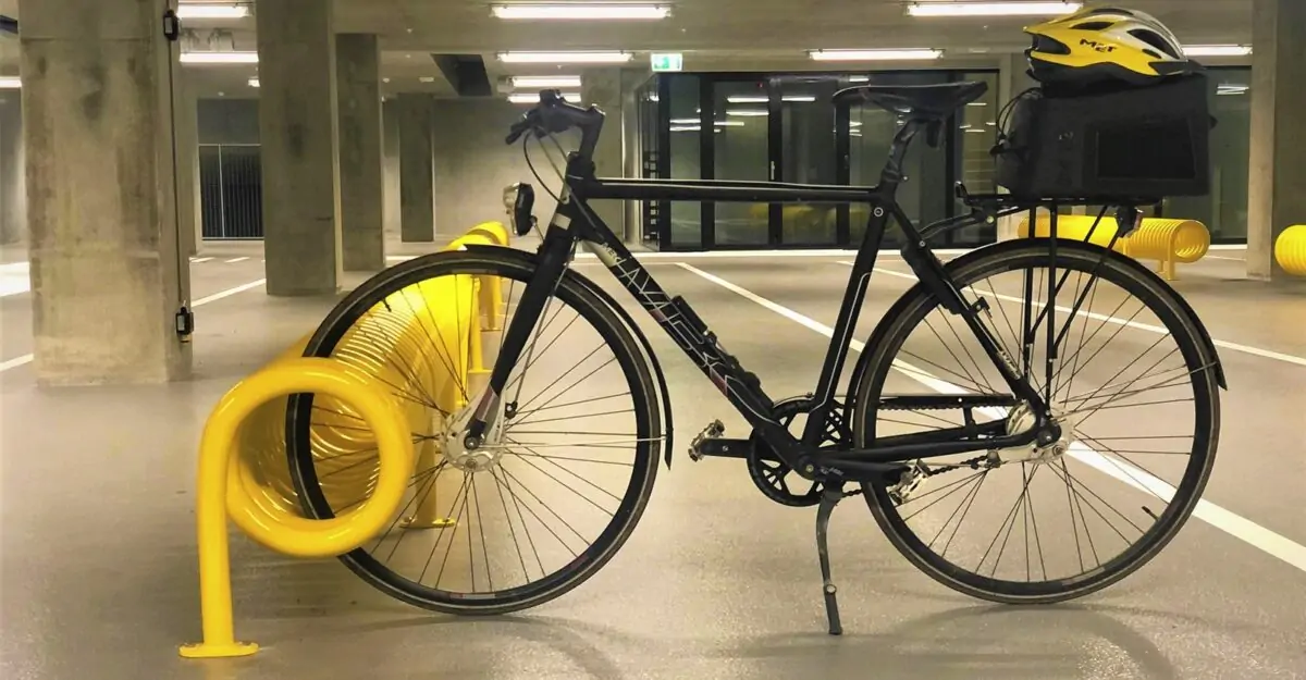 spiralformet cykelstativ i galvaniseret stål og malet i gul til parkering af mange cykler fra begge sider