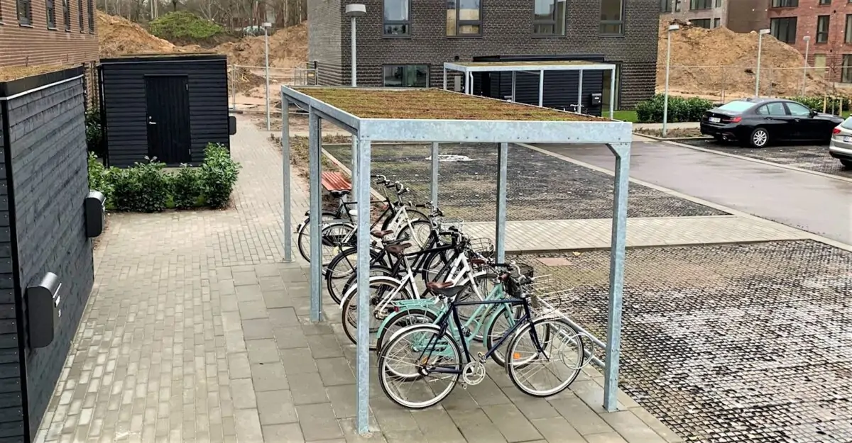 en enkel cykeloverdækning i galvaniseret stål med en række af cykelstativer til mange cykler og et sedum tag