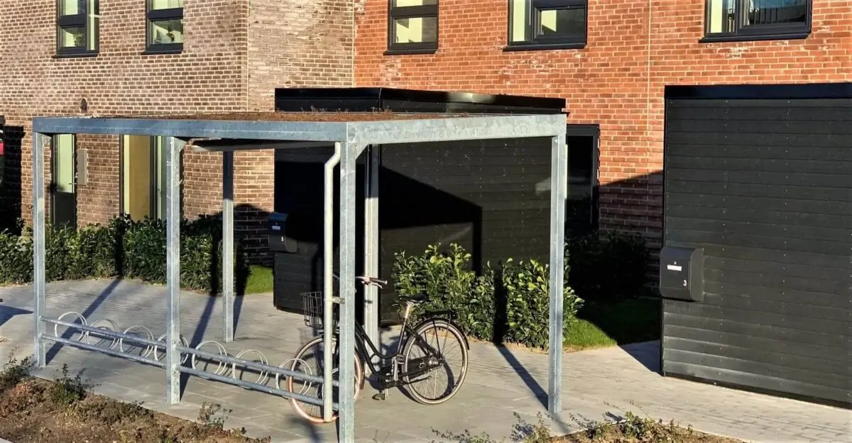 en enkel cykeloverdækning i galvaniseret stål med en række af cykelstativer til mange cykler og et sedum tag