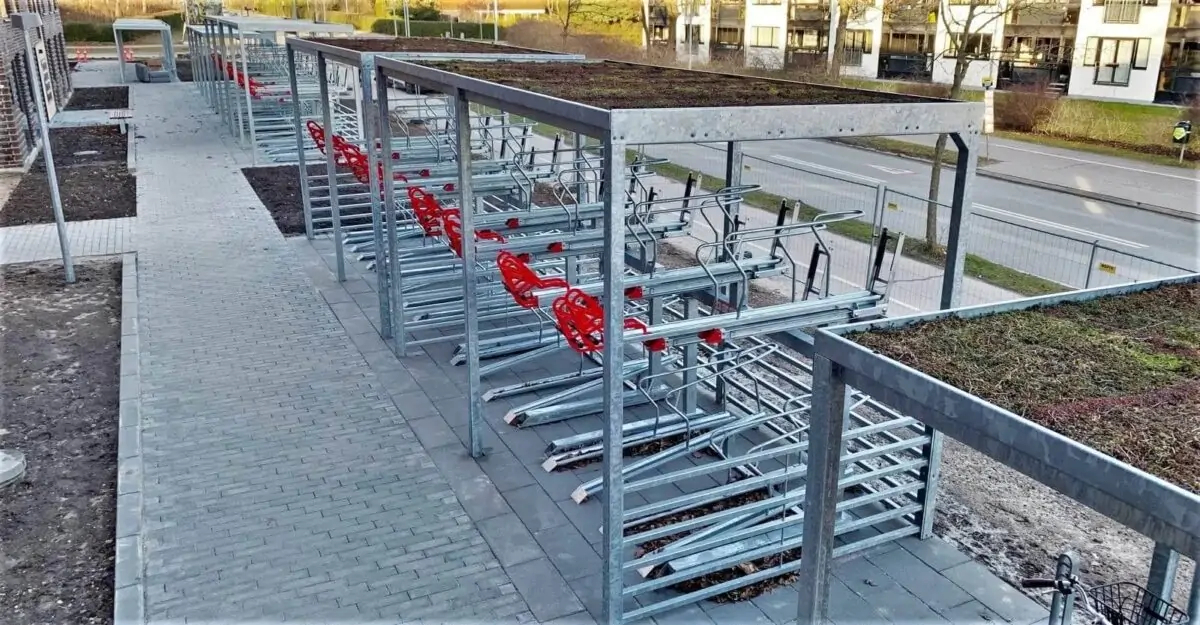 en stor dobbelt cykelparkering med cykelstativer i to etager til parkering af mange cykler under en overdækning