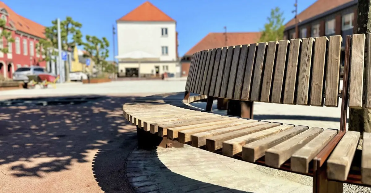 Crepa plint i cortenstål og beklædt med træ omkring et tre på Ringe Torv