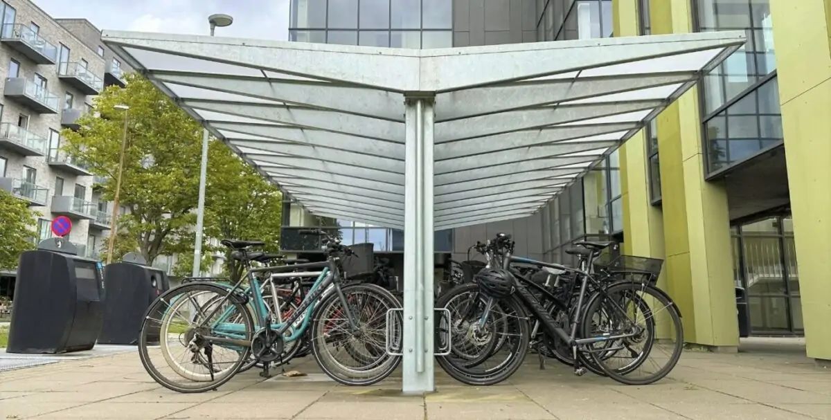 en cykeloverdækning i et stilrent og moderne design med et skråt og forstærket tag, fremstillet i galvaniseret og med plads til mange cykler