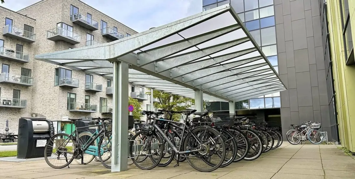 en cykeloverdækning i et stilrent og moderne design med et skråt og forstærket tag, fremstillet i galvaniseret og med plads til mange cykler