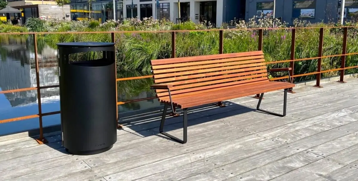 aarhus parkbænk med mahogni stave sammen med en sort skraldespand