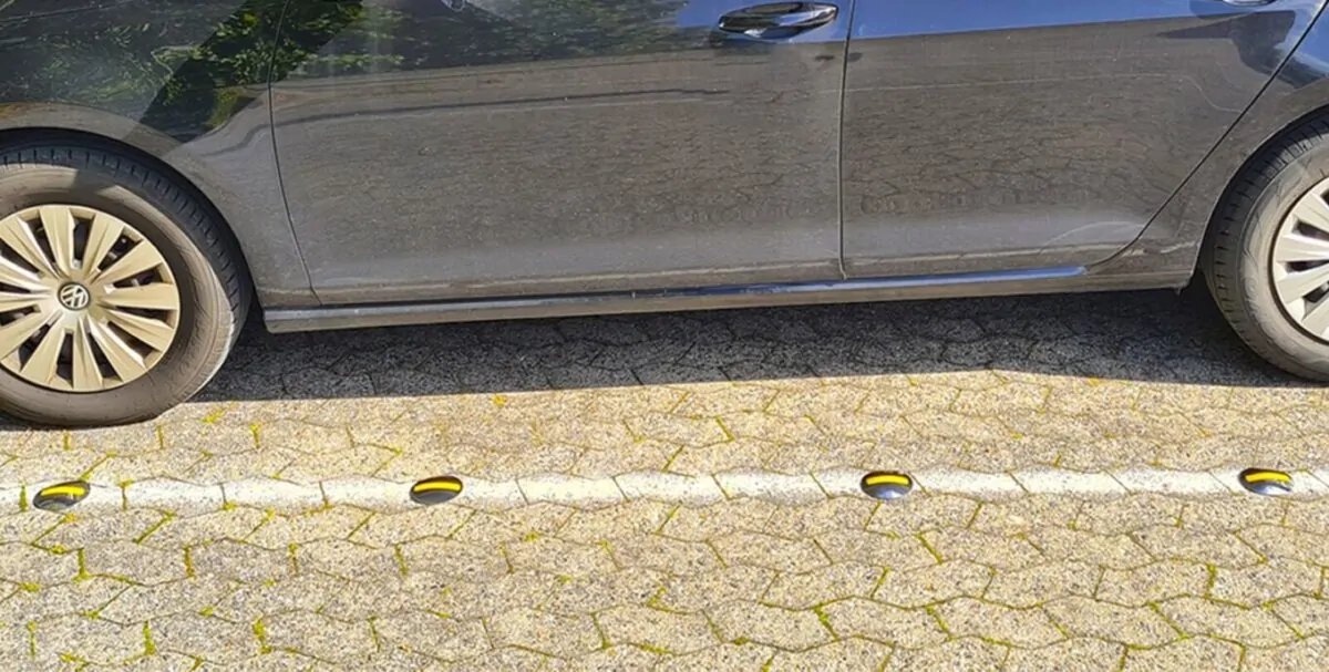 Rustfrit vejsøm (markeringssøm) med refleksbånd og rustfri spyd på parkeringsplads