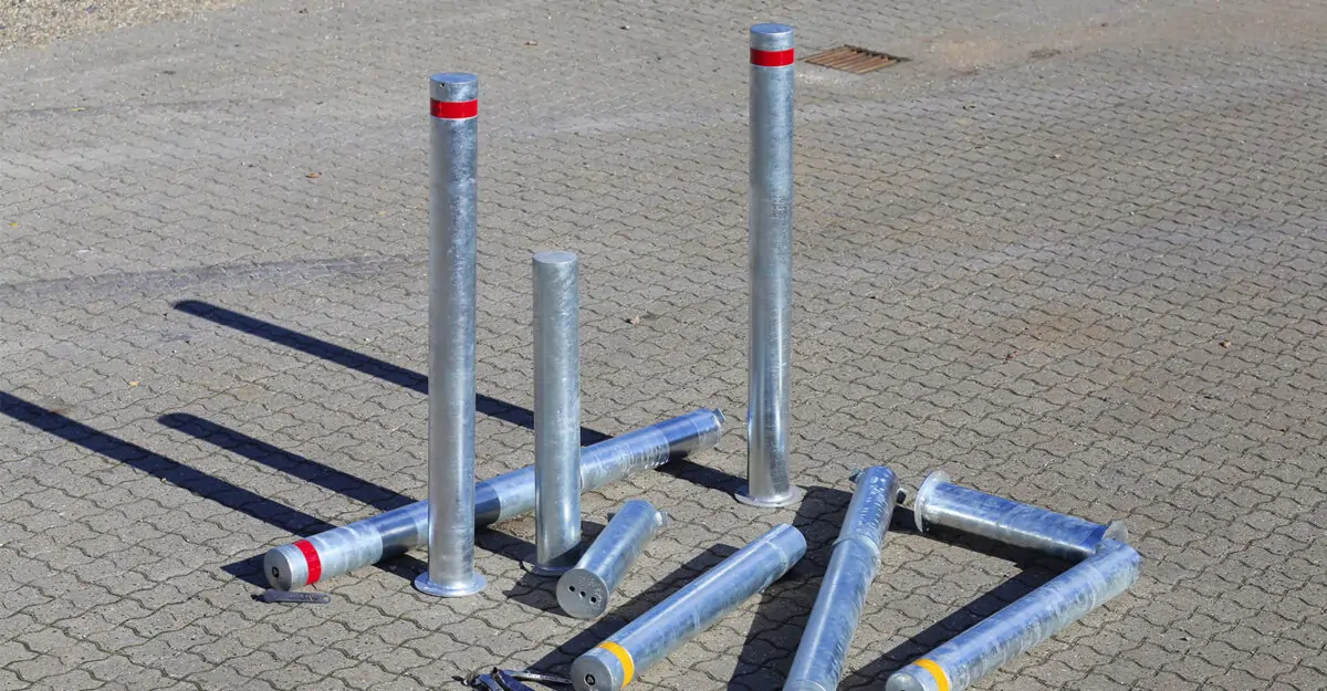 en gruppe klassiske aftagelige pullerter i varmgalvaniseret stål med røde og gule refleksbånd
