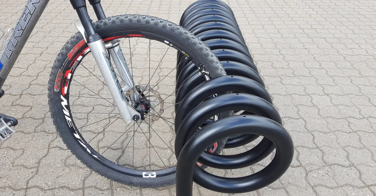 spiralformet cykelstativ i galvaniseret stål og malet i sort til parkering af mange cykler fra begge sider